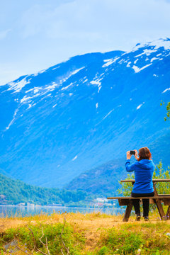 Tourist taking photo at norwegian fjord