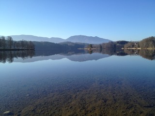 Impressing lake view with perfekt reflection of landscape in the Staffelsee near Murnau in Germany