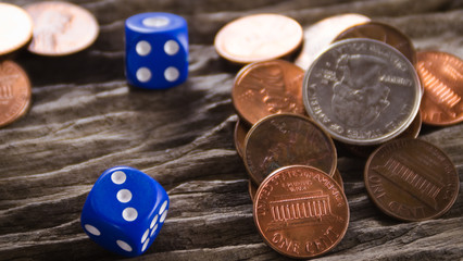 Dices and 1 Cent coins on wooden table