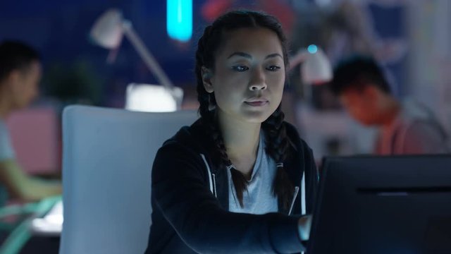  Portrait smiling computer game designer working at her desk