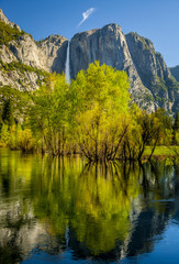Fototapeta na wymiar Waterfall with trees reflected in river