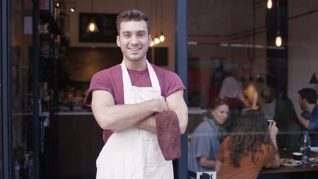  Happy Male Business Owner Standing In The Doorway Of Cafe