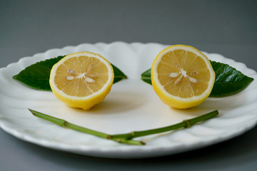 Organic lemon and leave on white plate with the gray background - Isolated