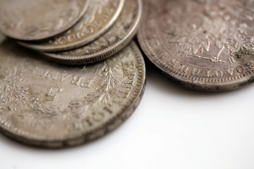 Close up of an old silver coins on white background; old money background.