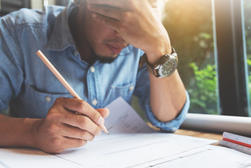 Stressed Asian Freelance designer. Close up man thinking about his job.