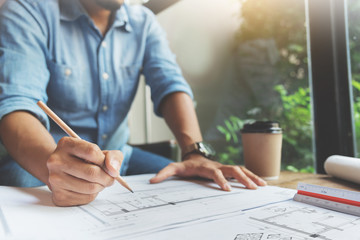 Close Up man hand writing on document papers with pencil. Freelance designer drawing his job.