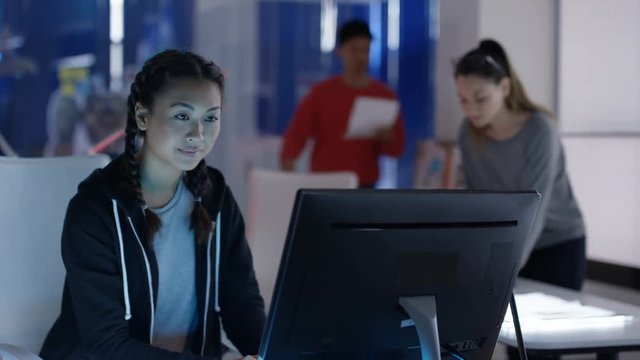  Young Asian computer design team collaborating on project in creative office