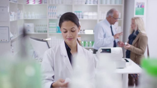  Team of staff working & serving customers in a chemist shop