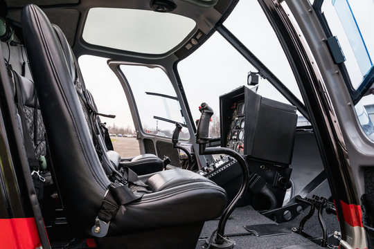 Helicopter cab interior, side view of the seat and the dashboard. Heli on the ground.
