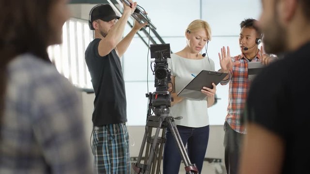  Behind the scenes with TV or film  production crew working together on set. 