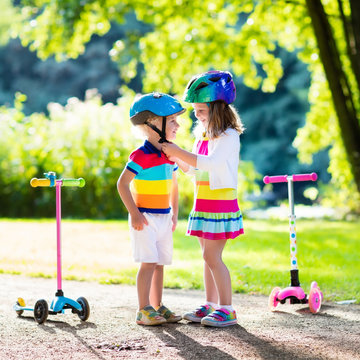 Kids riding scooter in summer park.