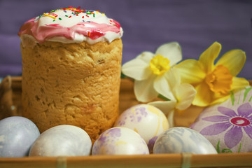 Easter cake and eggs with daffodilson blue background