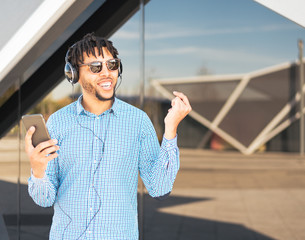 young man using his phone and listening music close up isolated happy outdoor