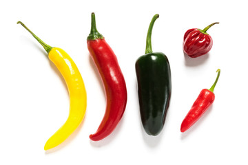 Various hot chillies on white background