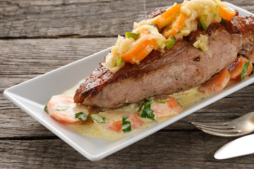 Gebratene Entenbrust auf einem Teller und Tisch aus Holz