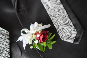 Corsage boutonniere brooch on a man groom suit on wedding day.