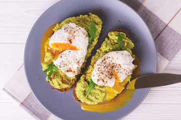 Toast with poached egg, puree avocado, spices and arugula