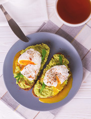 Toast with poached egg, puree avocado, spices and arugula
