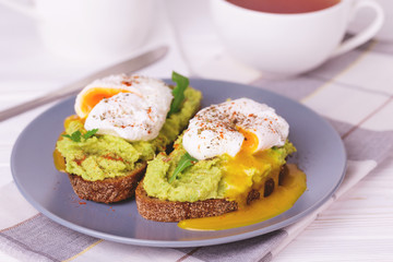 Toast with poached egg, puree avocado, spices and arugula