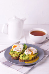 Toast with poached egg, puree avocado, spices and arugula