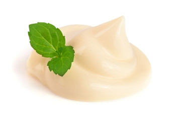 Mayonnaise swirl with a mint leaf isolated on a white background close-up