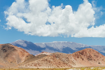 Orange hill with peaks behind in Catamarca, Argentina