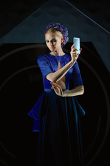 Beautiful fashion model holding smartphone in her hands. Presentation.