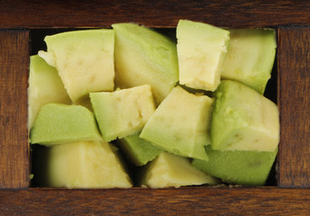 avocado slices in wooden box isolated