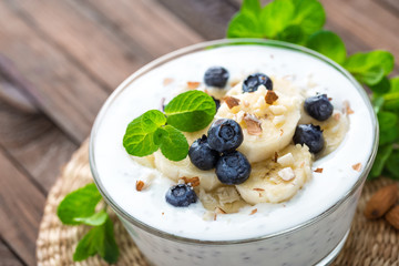 Yogurt with fresh blueberry, banana and almond nuts, delicious dessert for healthy breakfast