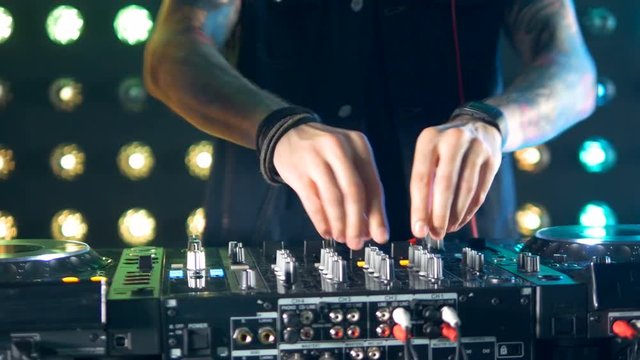 Male dj hands playing music, standing behind the turntables. 4K.