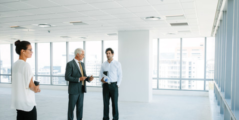 Fototapeta premium Real estate agent talking with clients inside an empty office sp