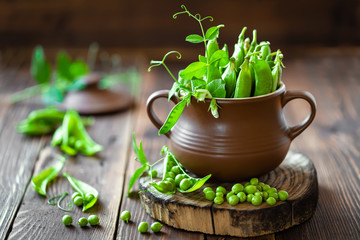 Fresh green peas on dark wooden rustic background