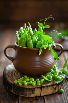 Fresh green peas on dark wooden rustic background