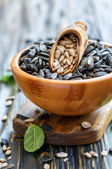 Bowl of sunflower seeds and wooden scoop.