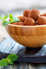 Chocolates and mint in a wooden bowl.