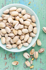 Pistachio nuts on wooden background, top view