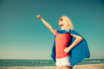 Superhero woman on the beach. Summer vacation concept