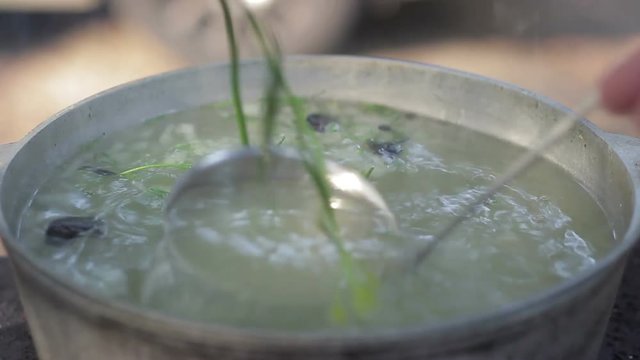 Cooking soup of fish in a metal pot outdoors