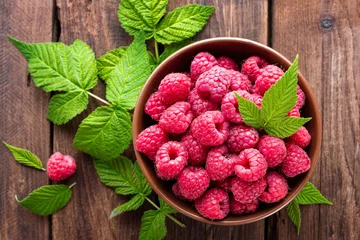 Poster Fresh raspberry with leaves on wooden background © Sea Wave