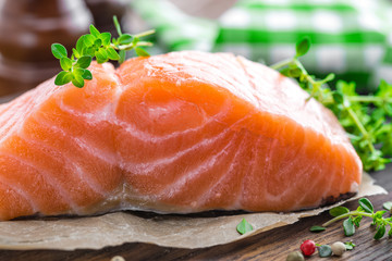 Raw salmon fish fillet on wooden board closeup
