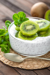 Fototapeta na wymiar Fresh kiwi yogurt with fruits and chia seeds, healthy breakfast