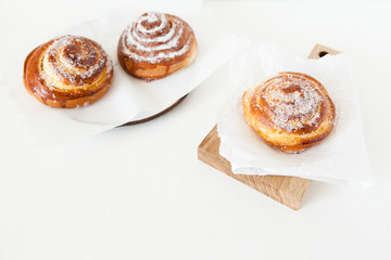 Obraz na płótnie Canvas Sweet rolls with sugar and cinnamon on white background.