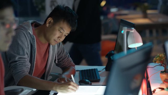  Young computer game designer drawing & working on computer