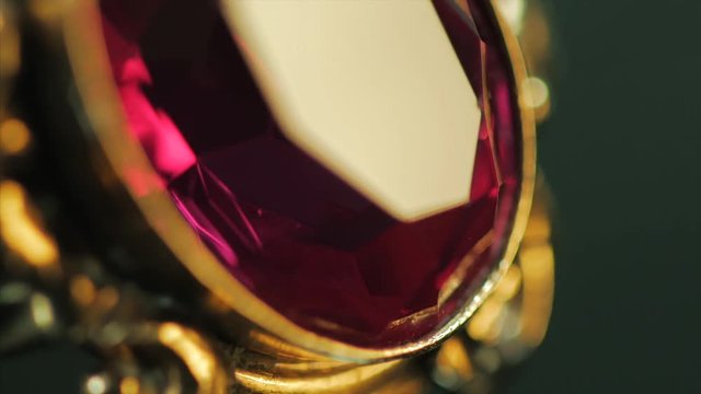 A close-up of a ring with a large red sparkling and shiny ruby