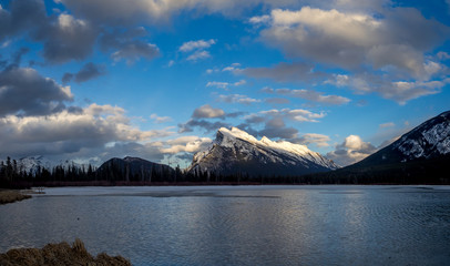 Mount Rundle reflected in the icy waters of Vermilion Lakes near Banff Alberta Canada at sunset.