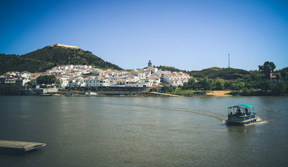 Fototapeta premium View of the village of Sanlucar on the banks of Guadiana river located in Spain taken from Alcoutim in Portugal. April 2017