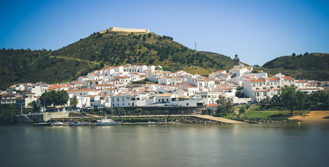 Fototapeta na wymiar View of the village of Sanlucar on the banks of Guadiana river located in Spain taken from Alcoutim in Portugal. April 2017