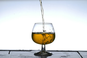 einschenken von gefärbten Wasser in einen Cognacschwenker