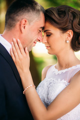 Beautiful couple walking in the park in their wedding day. Sunny weather.