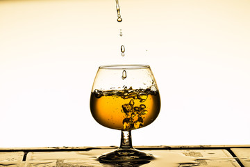einfüllen von eingefärbten Wasser in einen Cognacschwenker